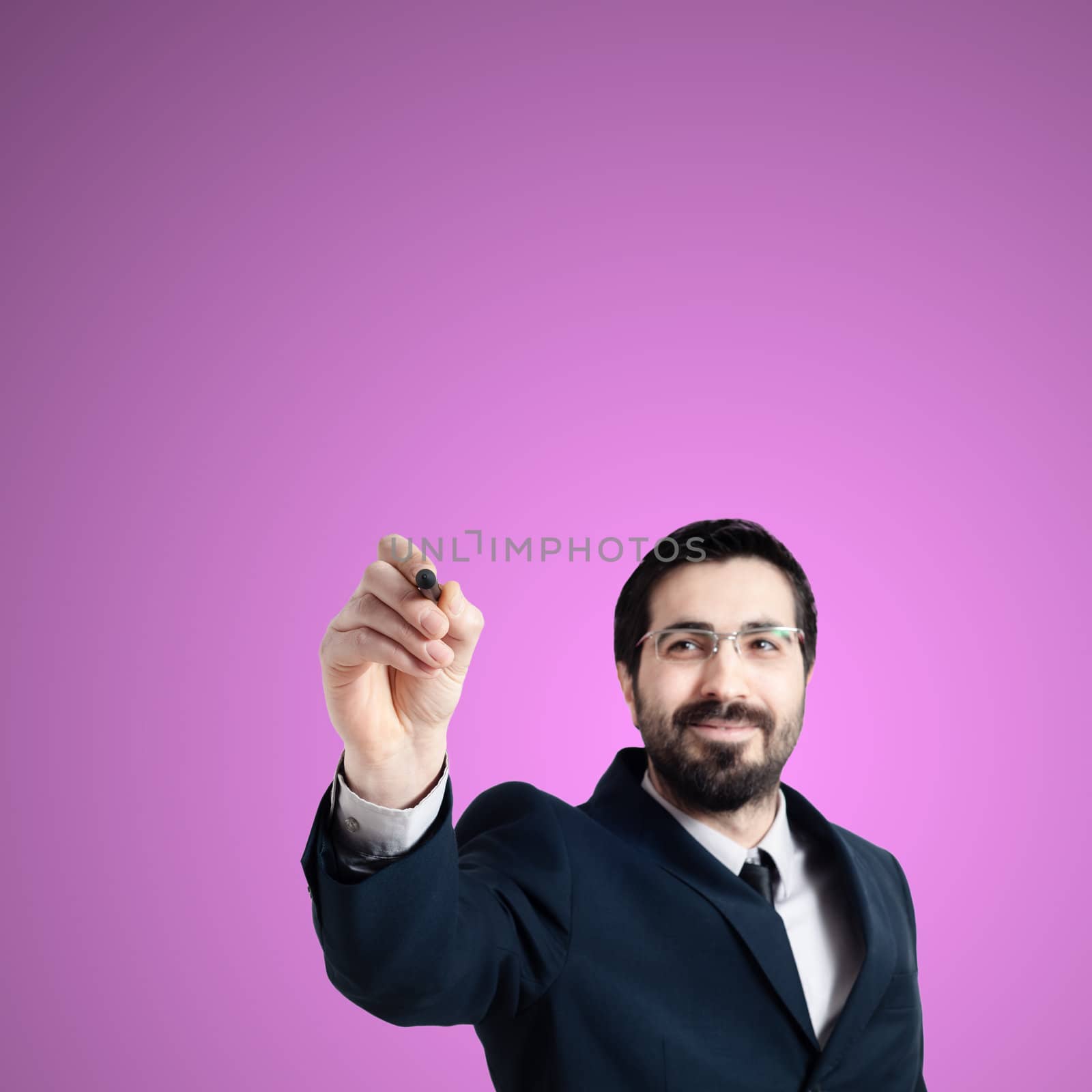 business man writing on imaginary screen on pink background