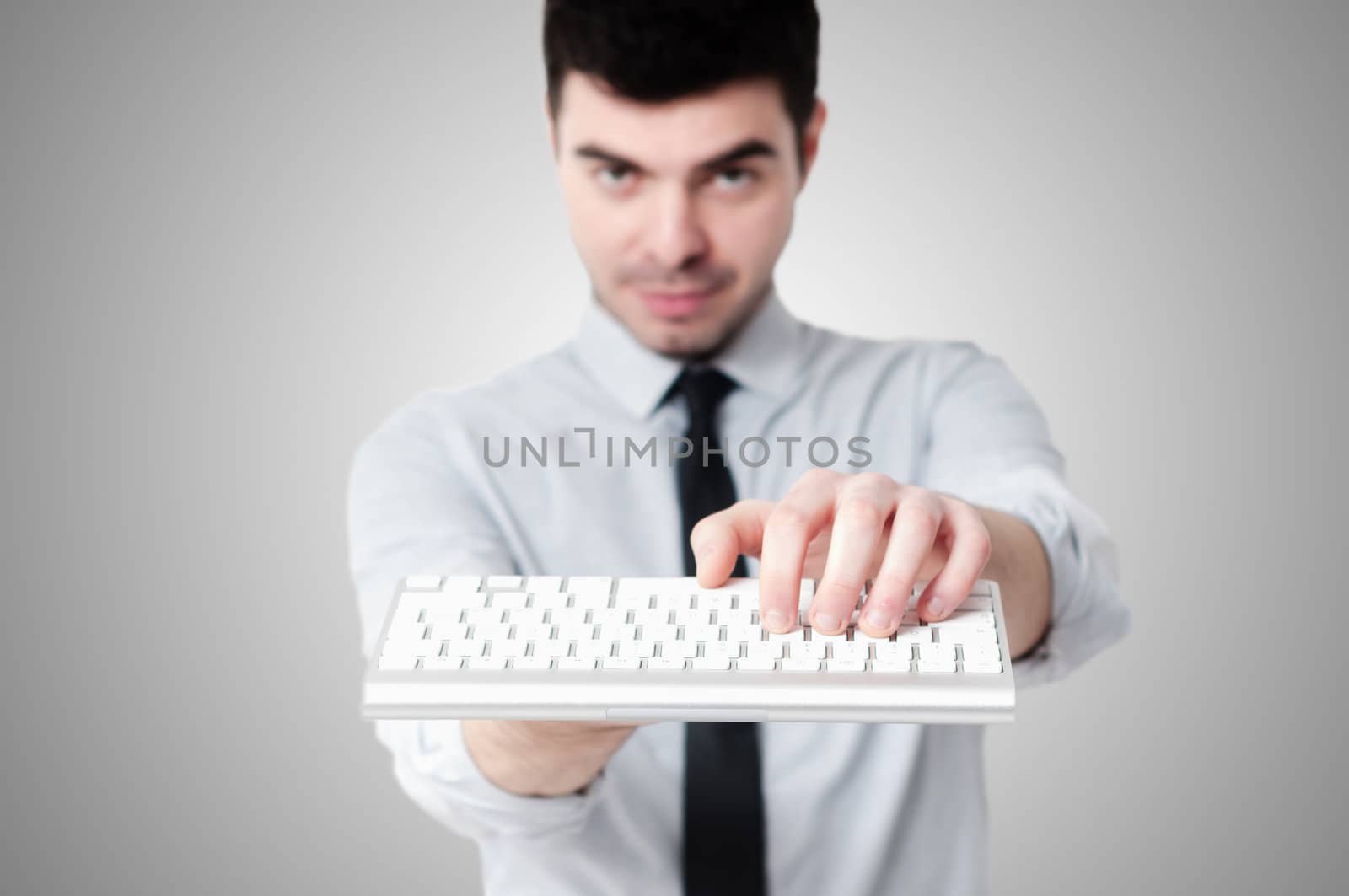 business man holding keybord n gray background