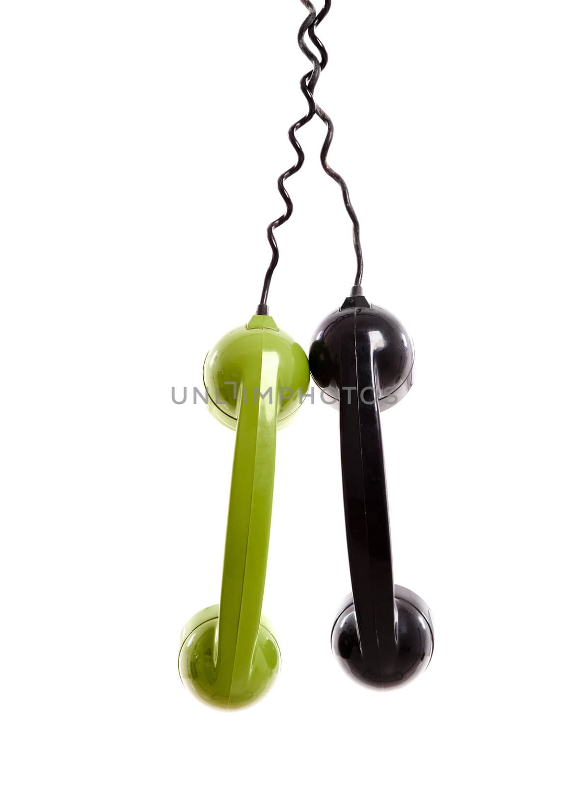 Two Handset piece from old phones suspended by the phone cord, isolated on white background