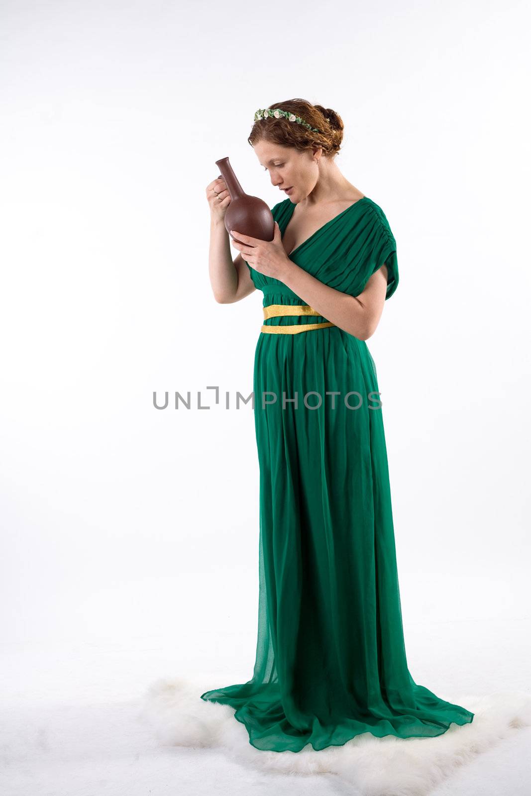 Lady in green antique dress handing jug on white background
