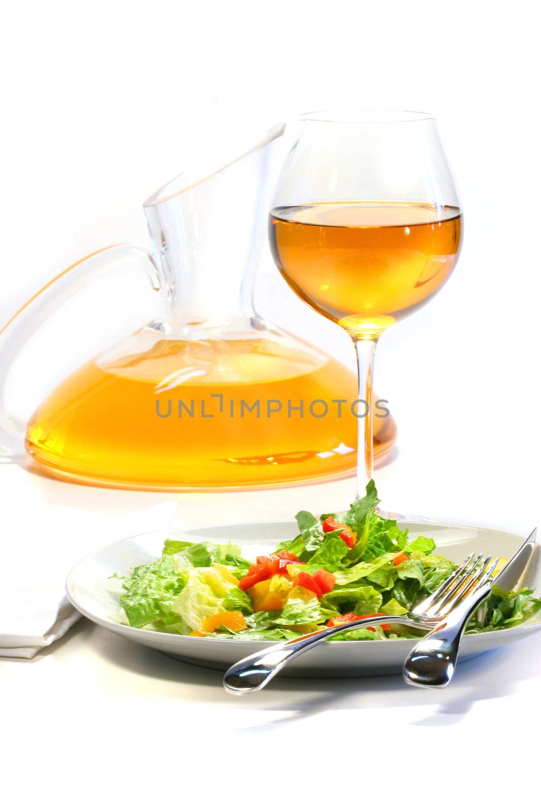 Plate of salad and wine glass on white background