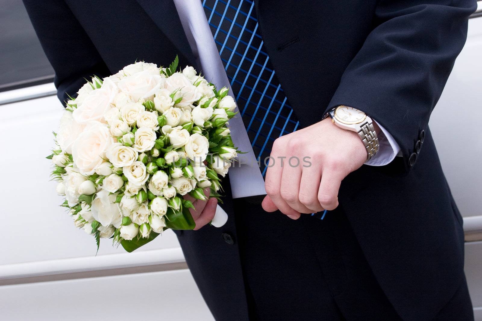 a man in suit with watch hands a flower bouquet by vsurkov