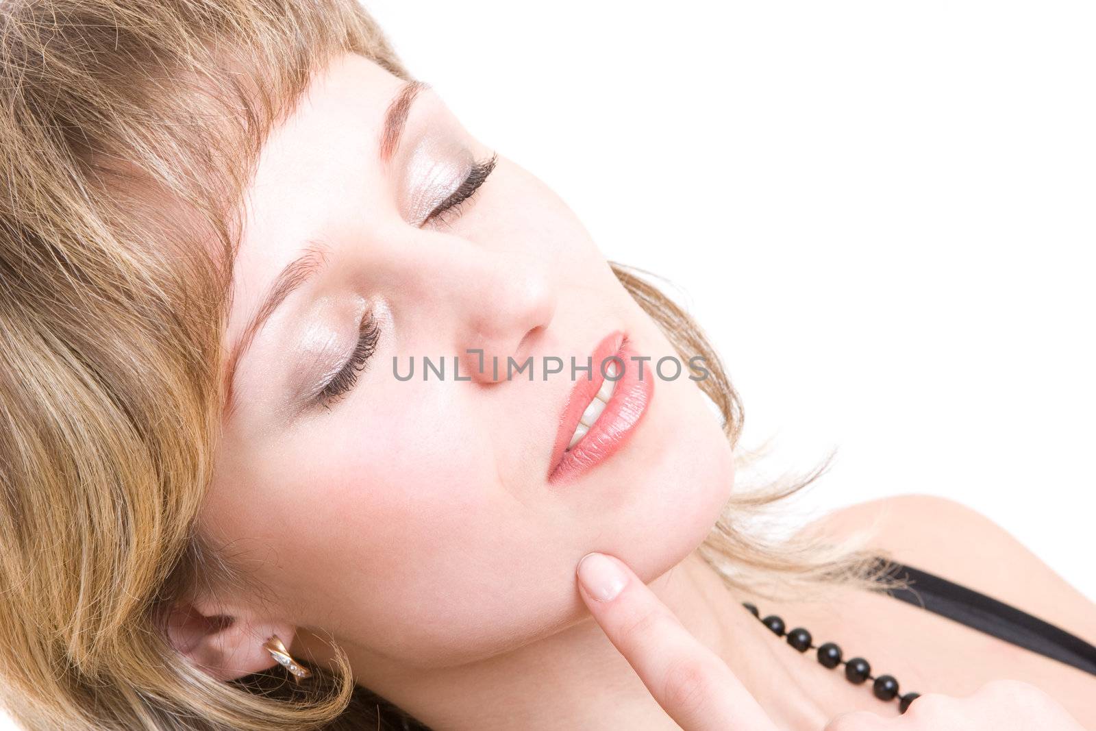 young girl with a happy smile closes her eyes and touches her cheek with one finger