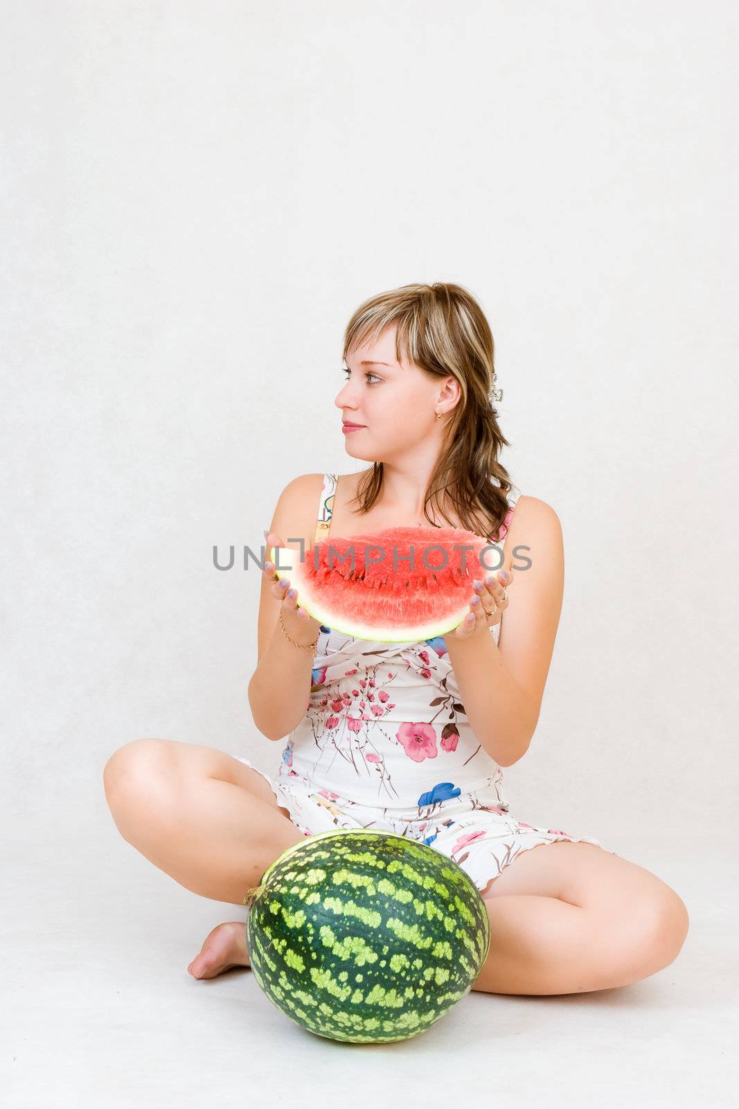 A sitting girl with a water melon in her hands by vsurkov