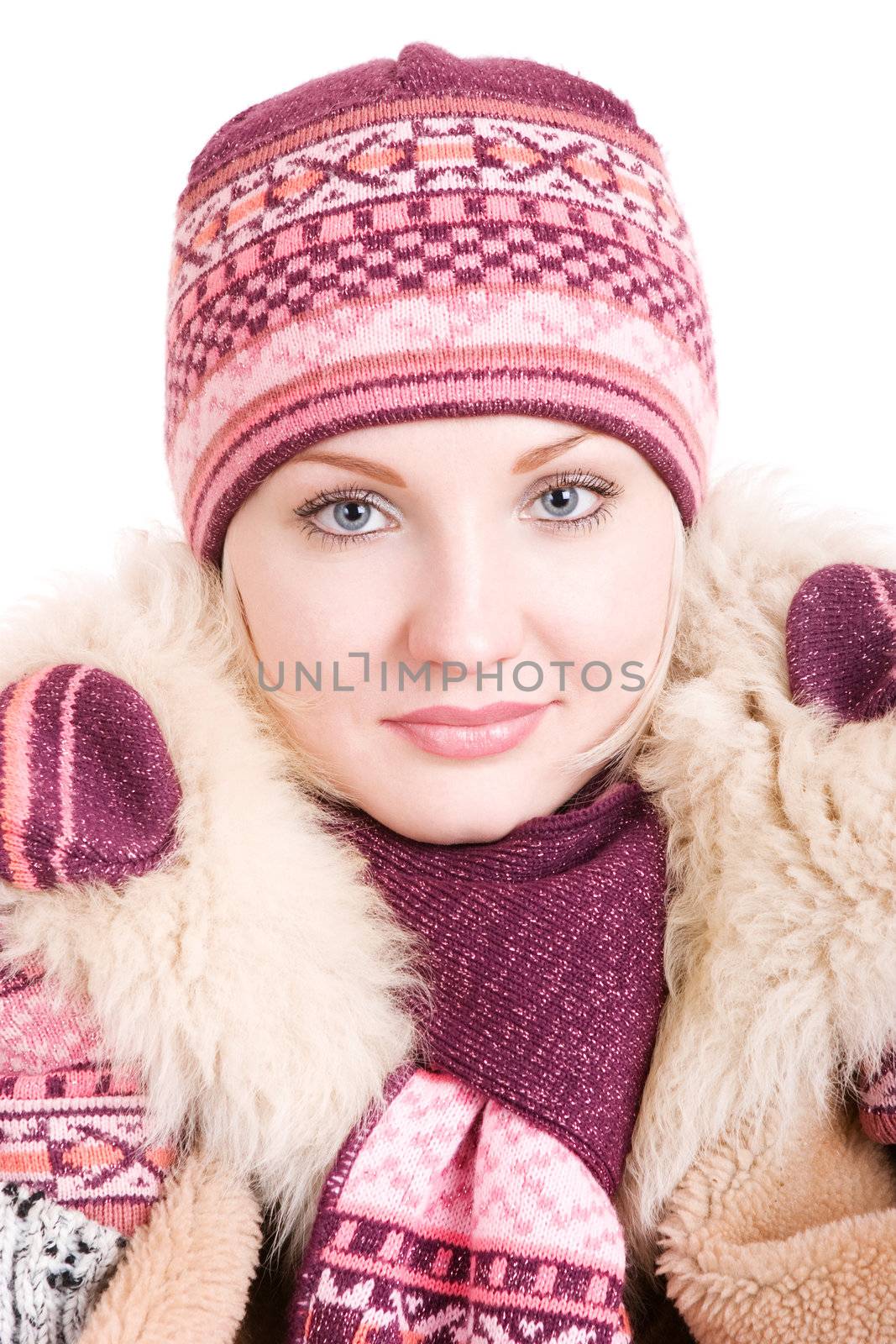 a smiling girl dressed in winter cap, coat, mittens and scarf looks up