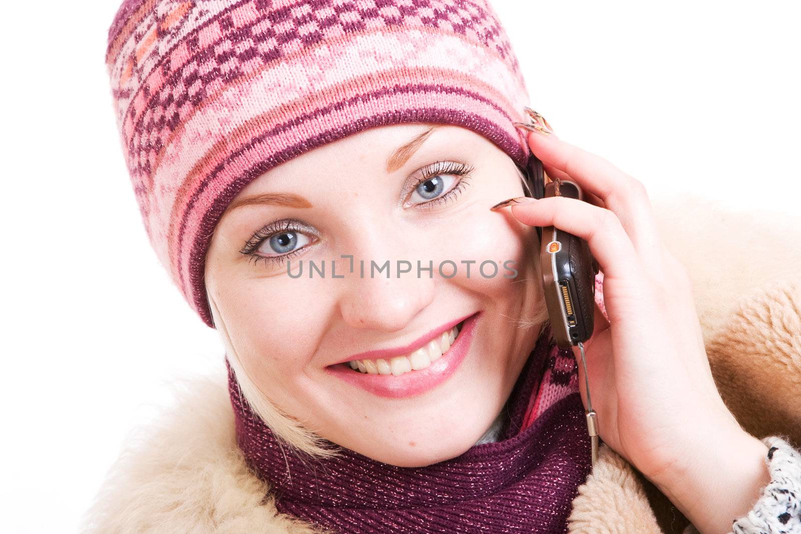 a smiling young Woman dressed for winter talks a mobile phone by vsurkov