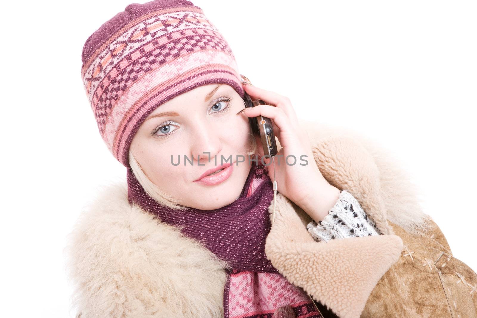 serious young Woman dressed for winter talks a mobile phone by vsurkov