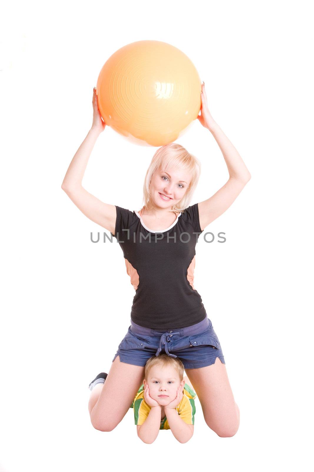 smiling happy young mother and her little son with a fitness ball on the floor