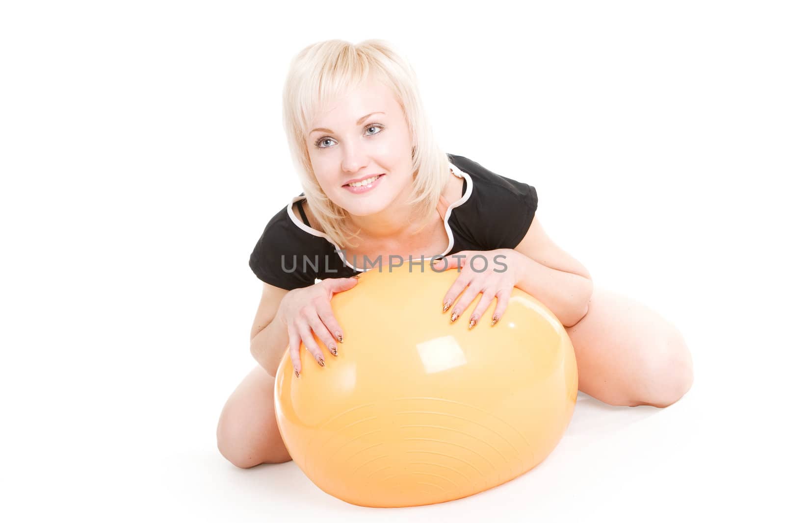 a beautiful smiling blond girl with a big fitness ball on the floor
