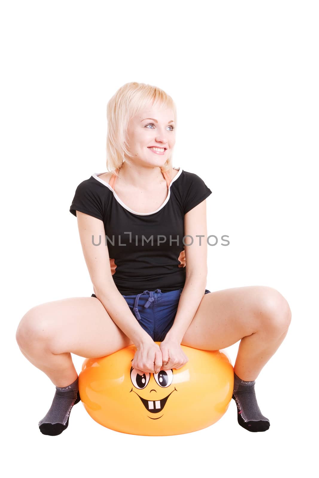 a wide smiling young woman going in for fitness sitting a big ball