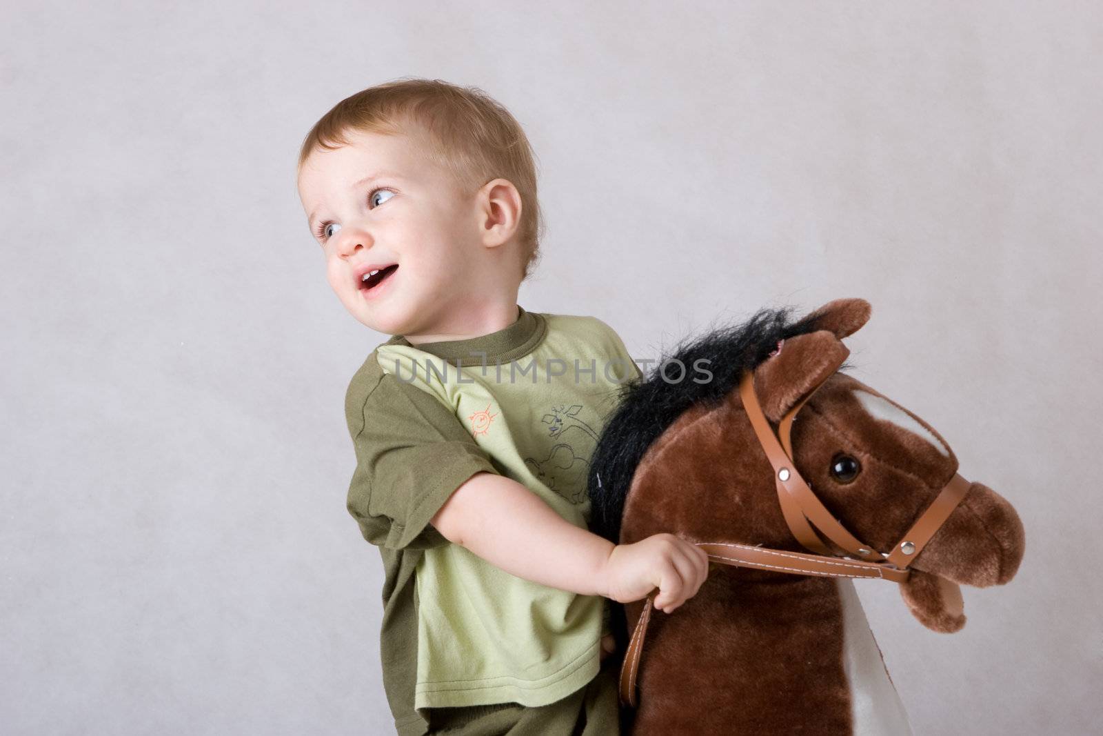 boy sitting on a toy horse by vsurkov