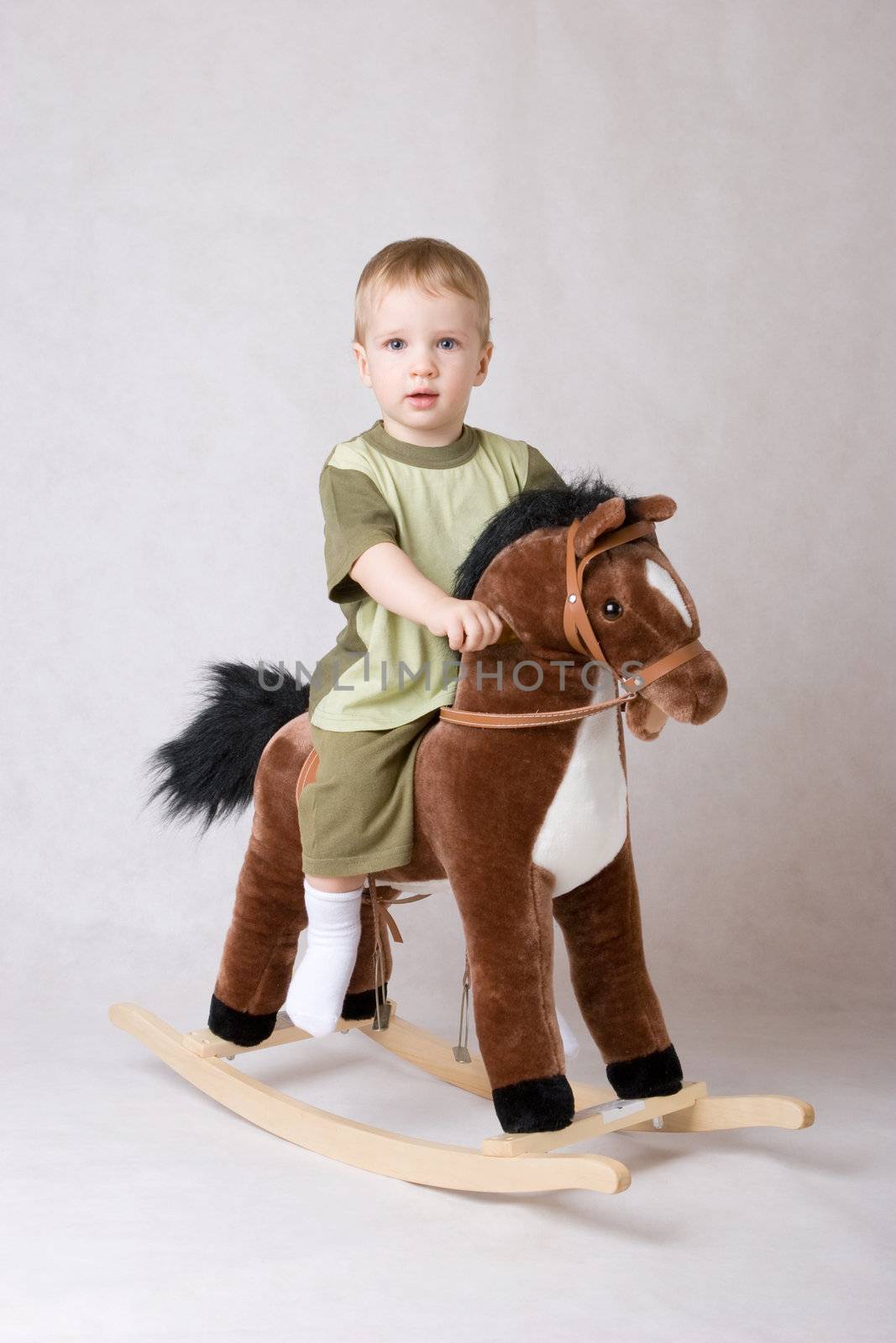 small boy riding a toy-horse