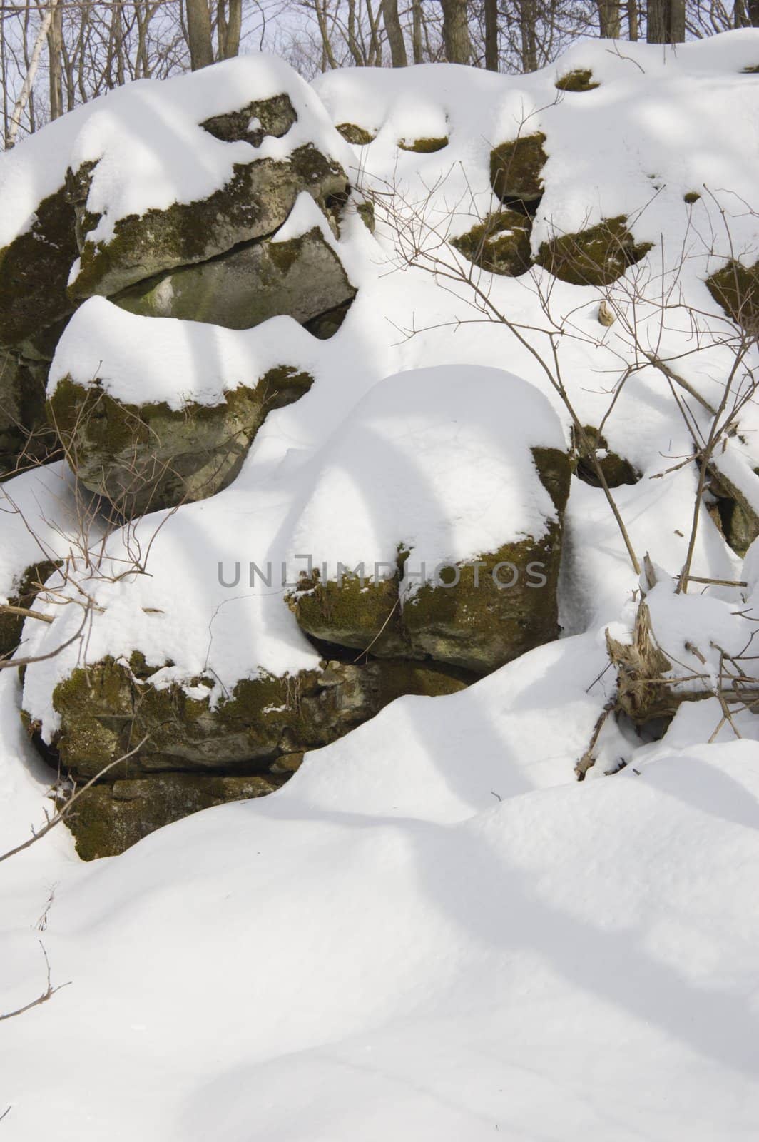 Rocks under snow in sunny winter day