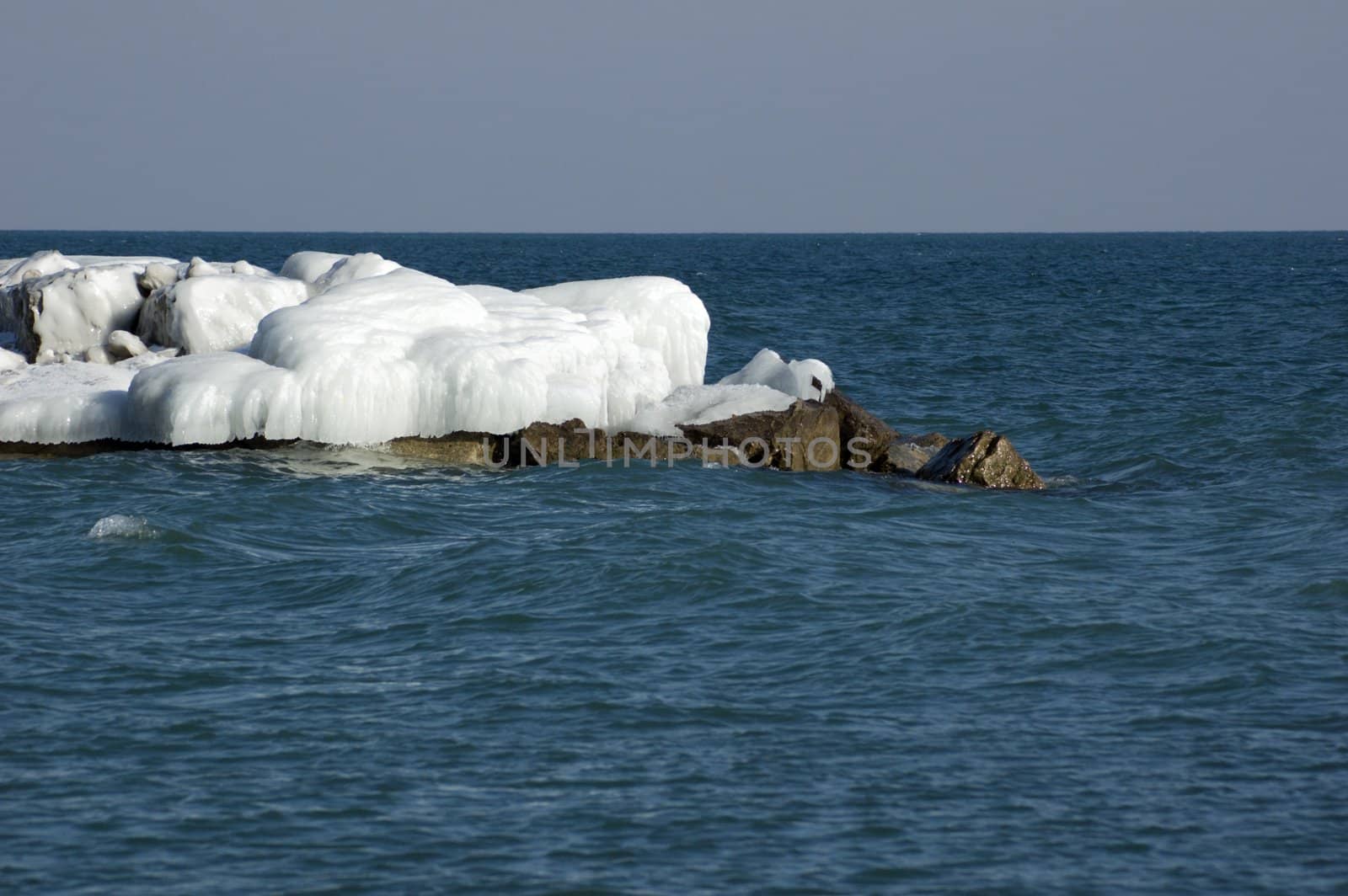 Ice island in Ontario lake in winter evening.