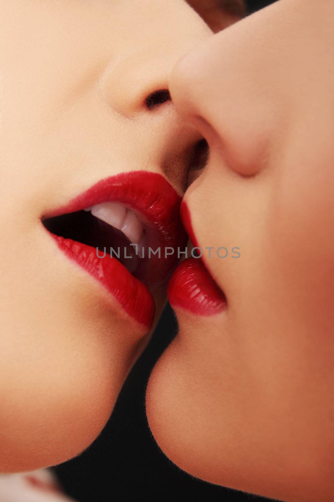 Closeup of pair women mouths kissing by BDS