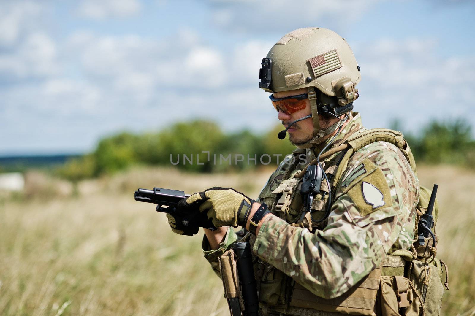 The soldier  in full gear reloads a gun