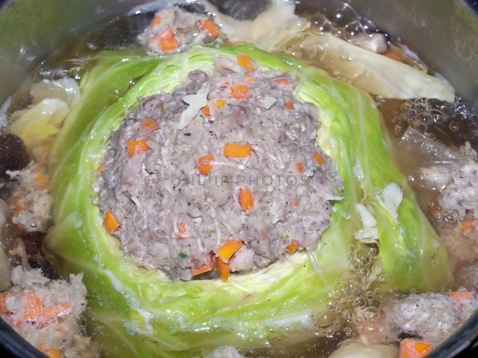 Minced pork mixed with flavouring stuffed in cabbage boiling in soup in pot, traditional Thai style food.