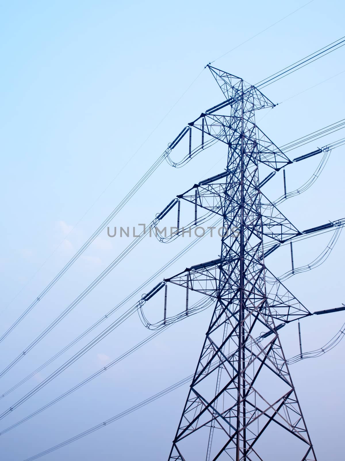 High voltage post against clear blue sky