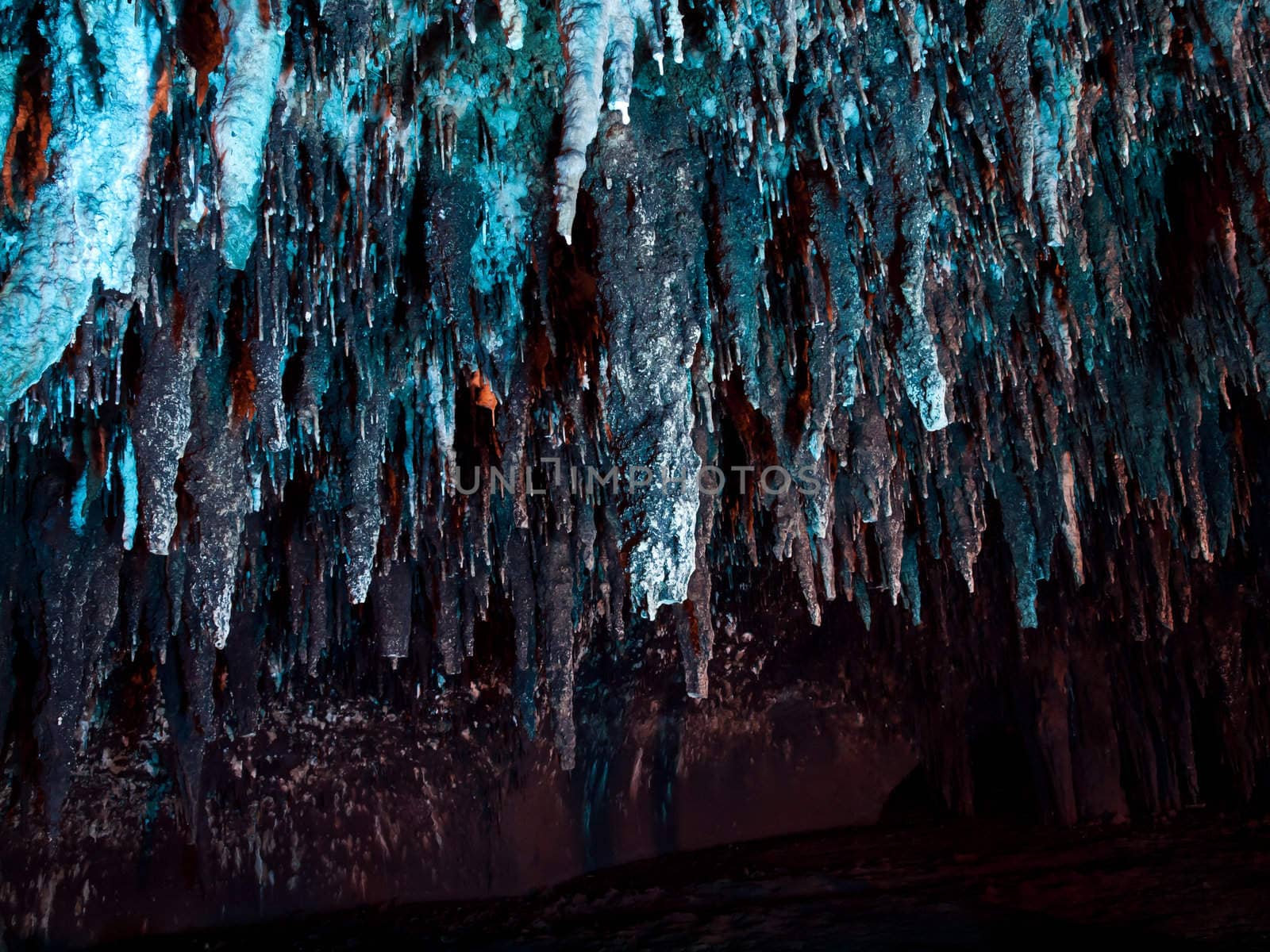 Stalactite wall illuminated with color light in Tham Khao Bin cave, Ratchaburi, Thailand