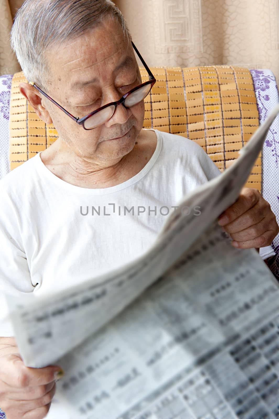 a senior man is reading newspaper