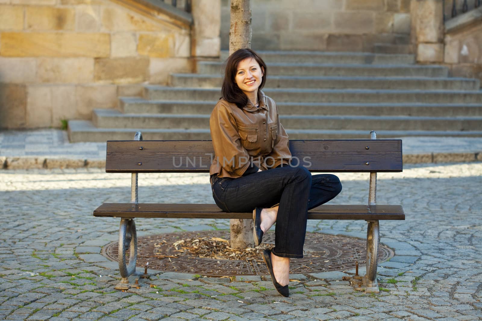 beautiful young woman sitting on a bench by jannyjus