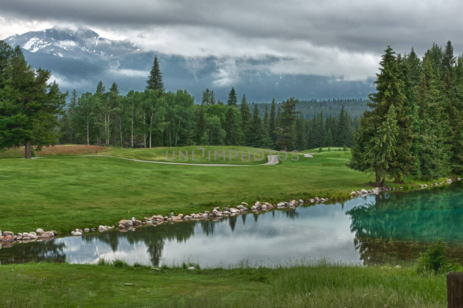 Golf course near lake near Jasper in the Canadian Rockies agains by Claudine
