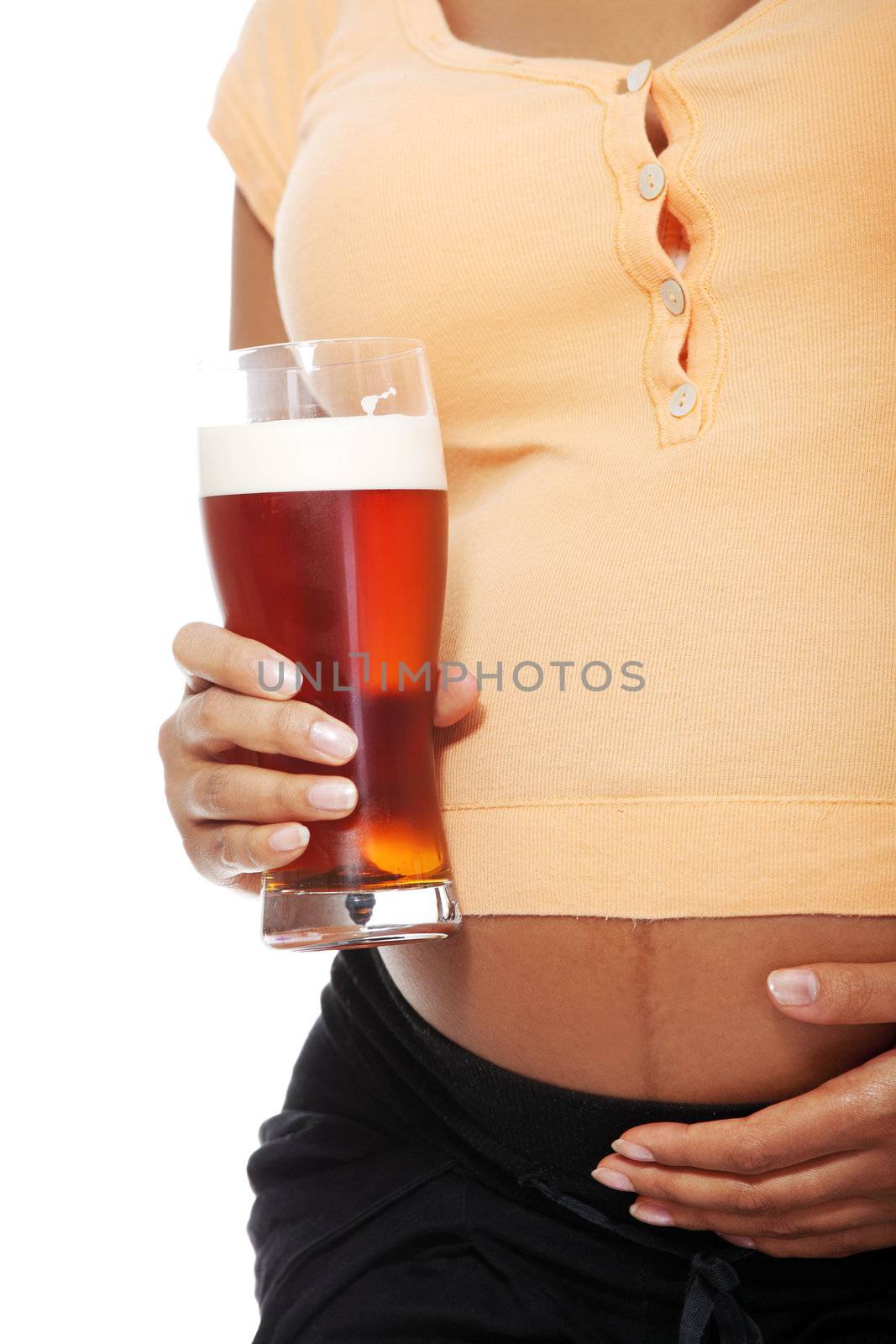Belly closeup of a pregnant woman holding a glass alcohol next to her belly, over a white backgroung.