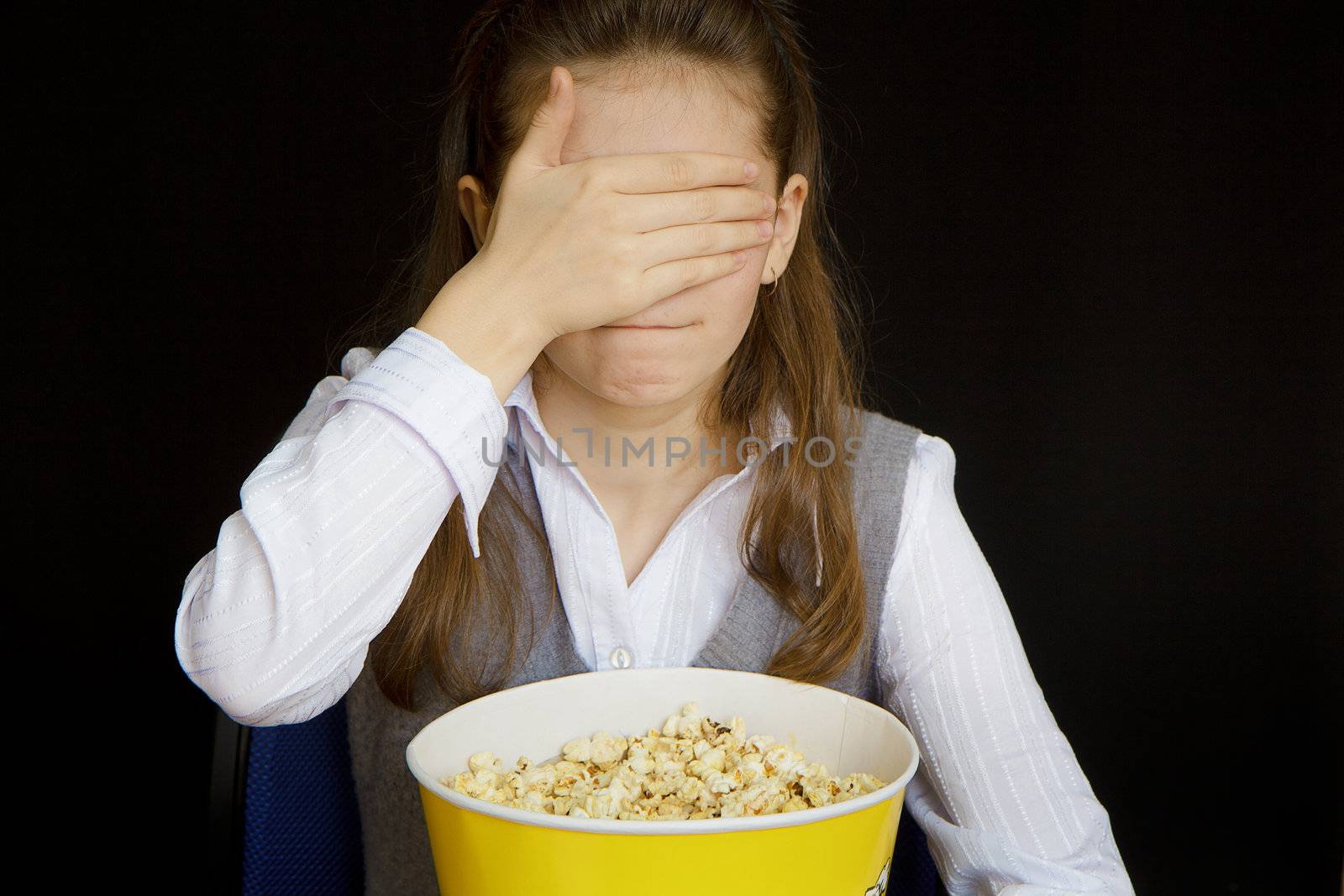 girl in a movie theater closes her eyes