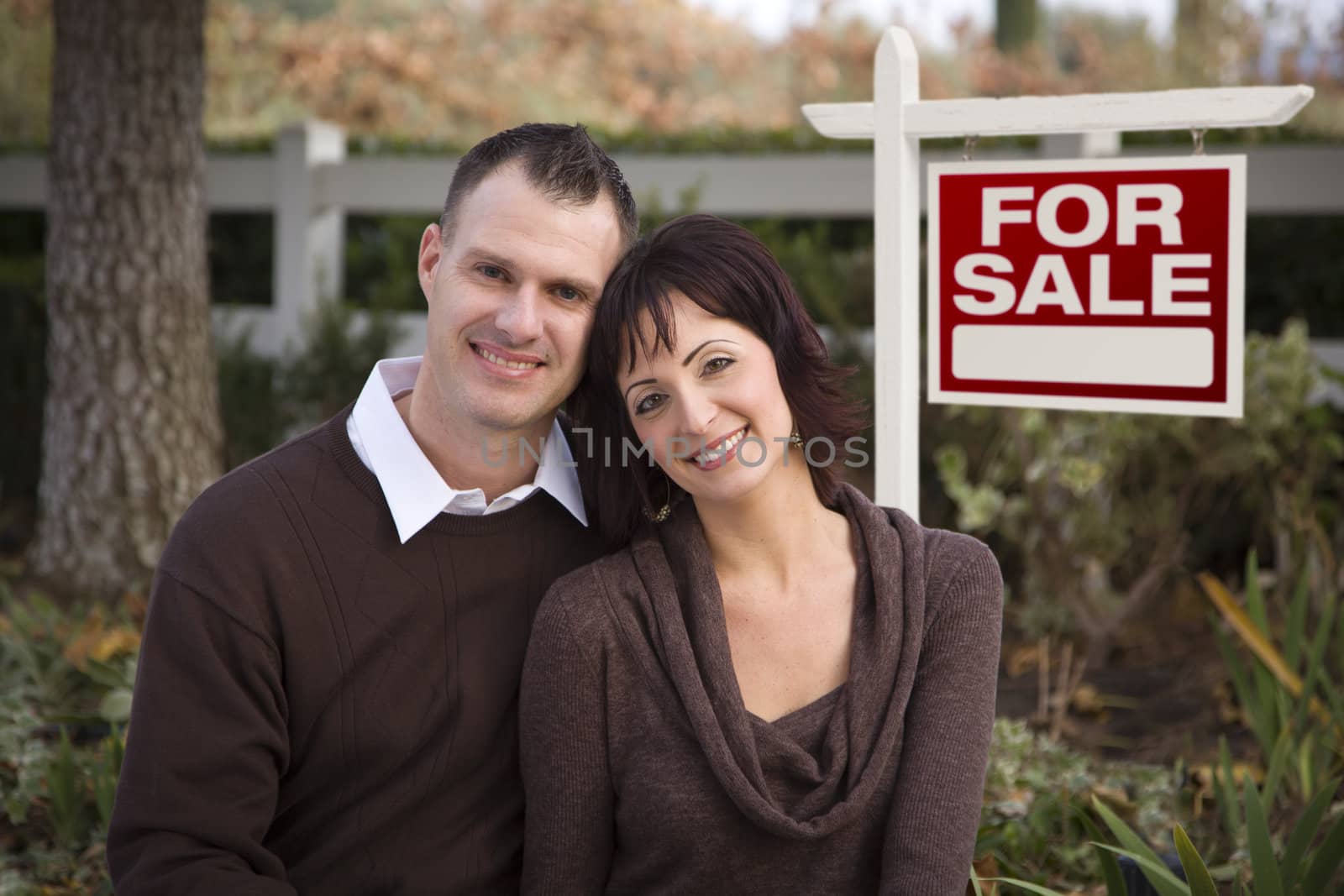 Happy Couple in Front of Real Estate Sign by Feverpitched