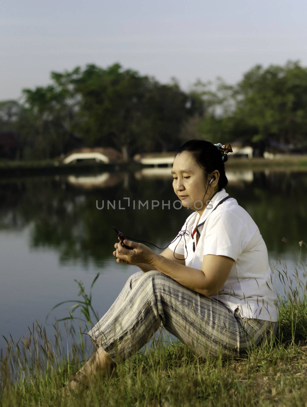 Woman Listening To MP3  by siraanamwong