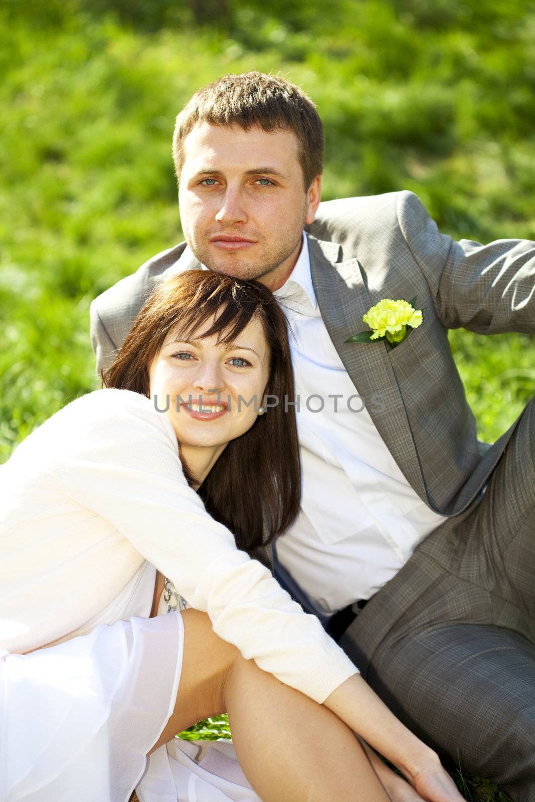  just married in a flowering garden sitting on the grass