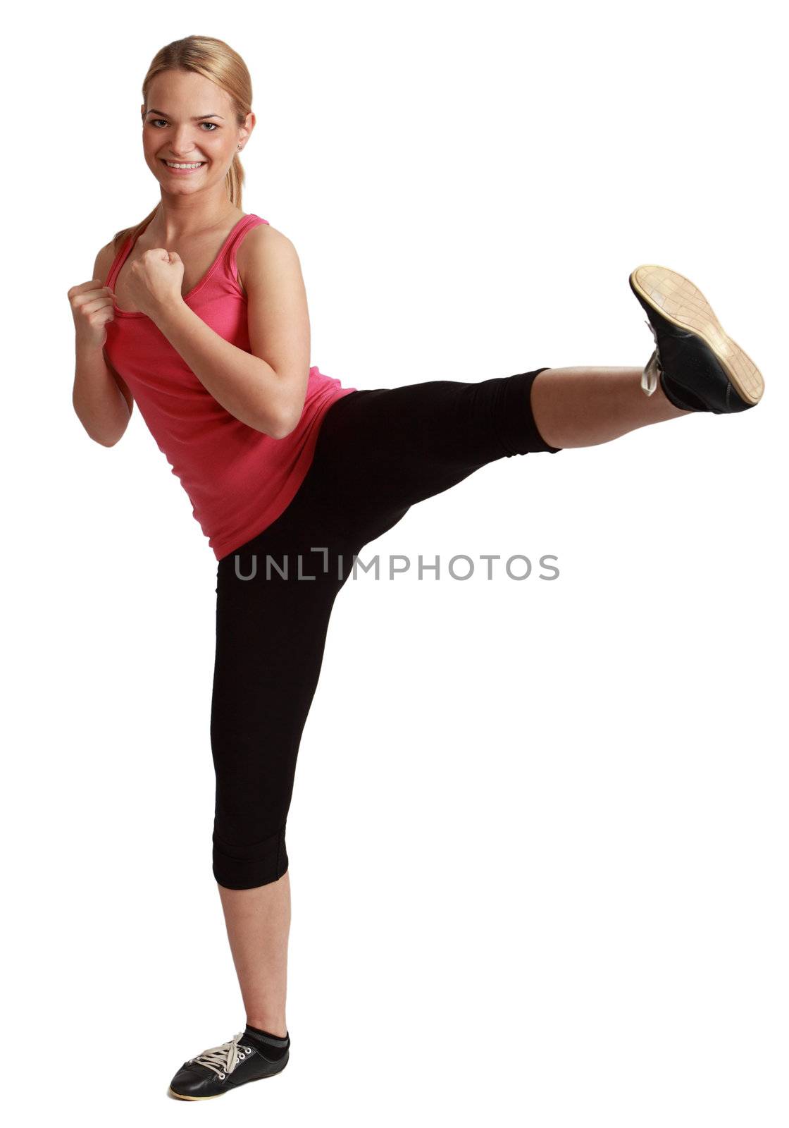 Young blonde woman kickboxing against a white background.