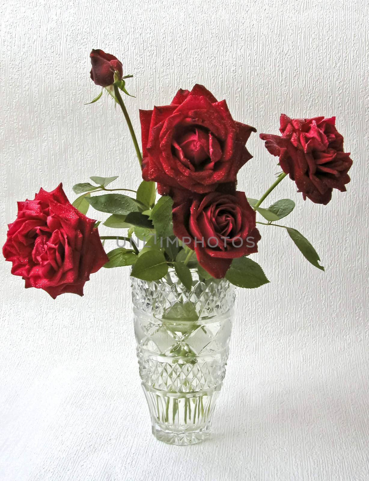 festive bouquet of the roses in crystal vase on silvery background