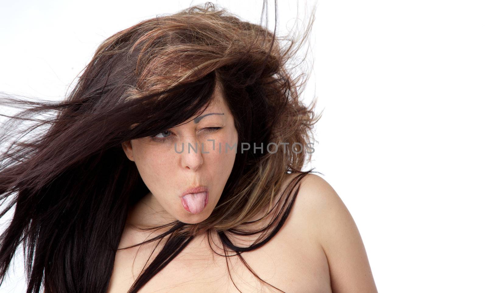 Portrait of topless young girl with tongue out on white background
