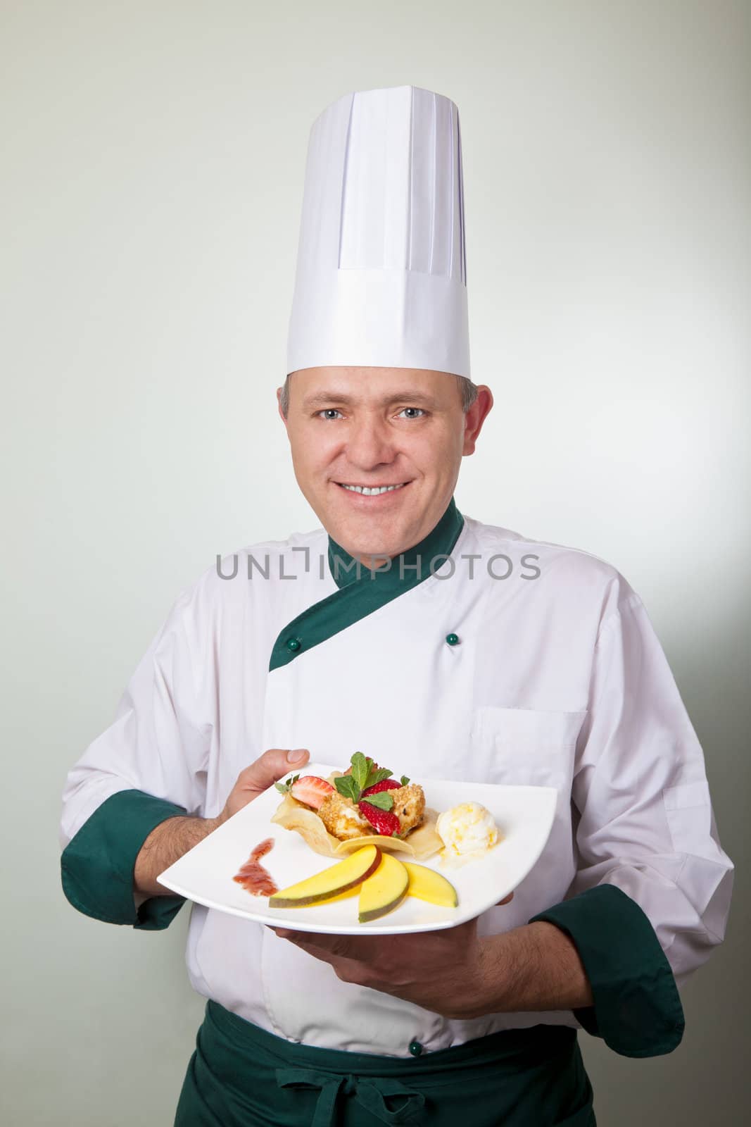Chef holding fruit dessert by vilevi