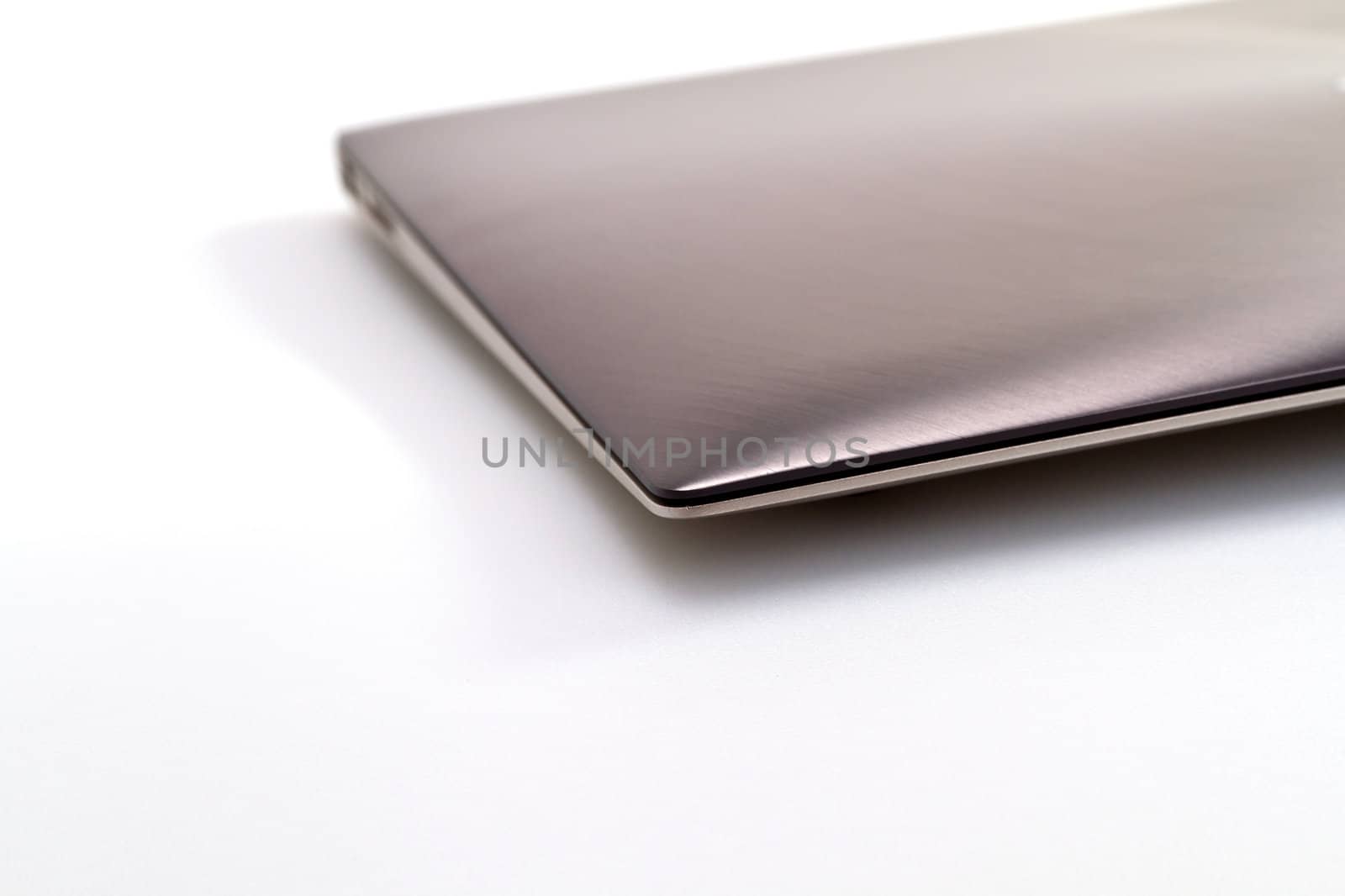 a modern metal laptop with closed lid on white background for abstract background