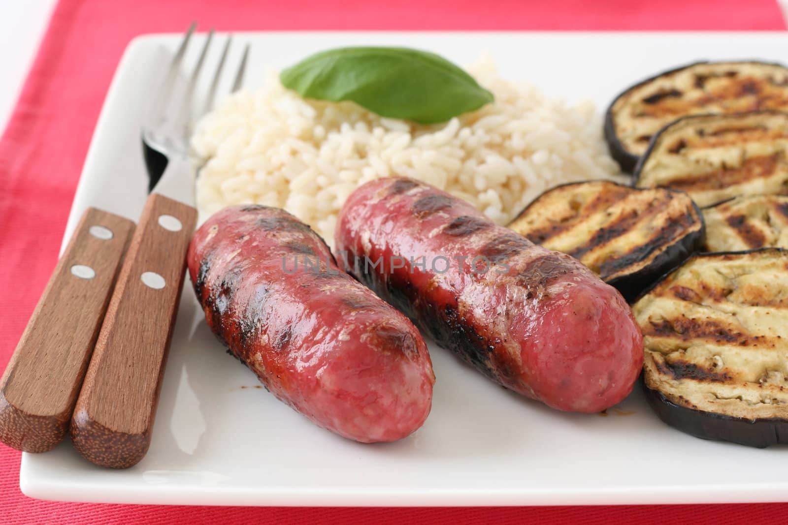 grilled sausages with rice on the plate by nataliamylova
