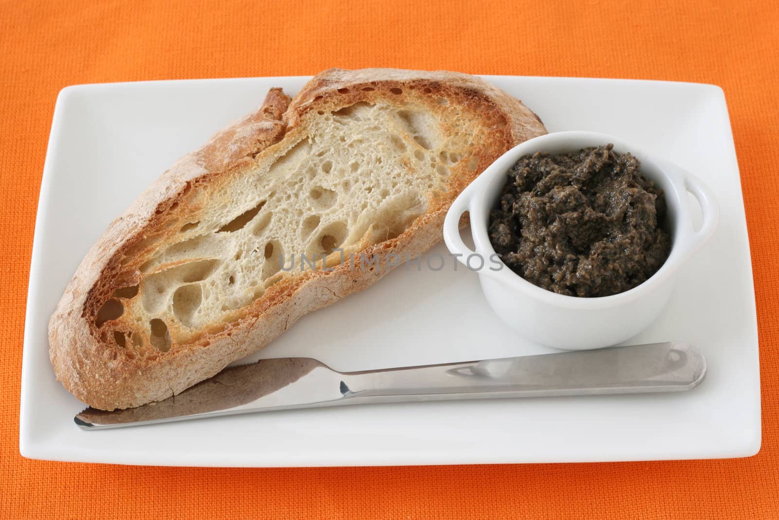 bread with olive paste in the bowl by nataliamylova