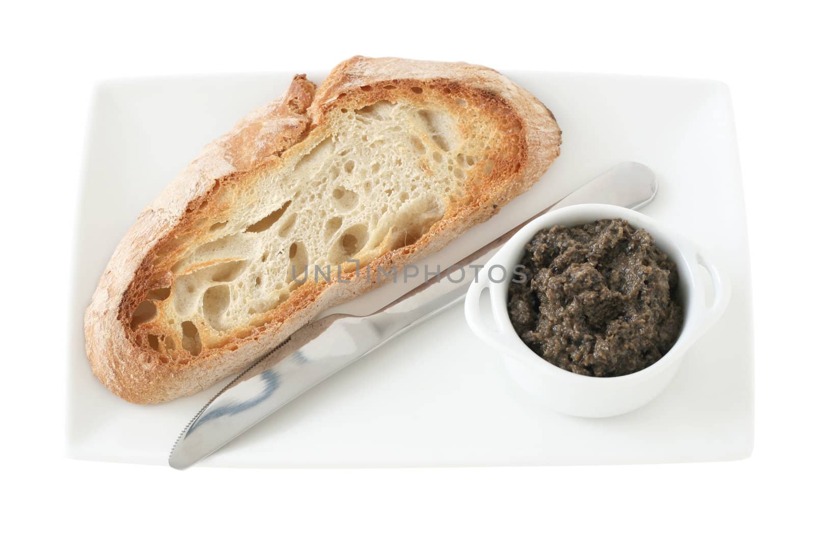 bread with olive paste in the bowl by nataliamylova