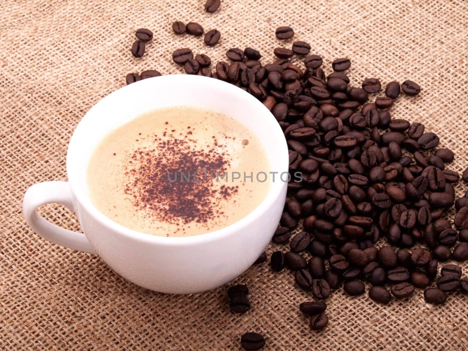 Coffee beans with cup on canvas  by motorolka