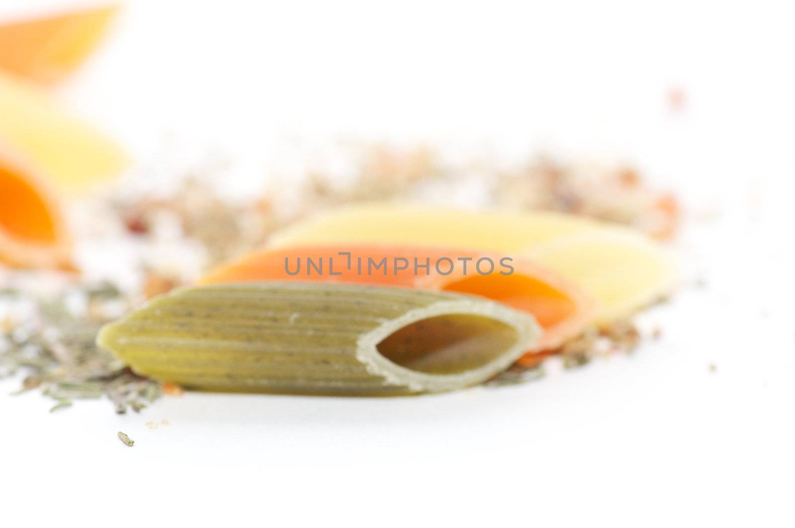 Multi colored macaroni with spices on white background