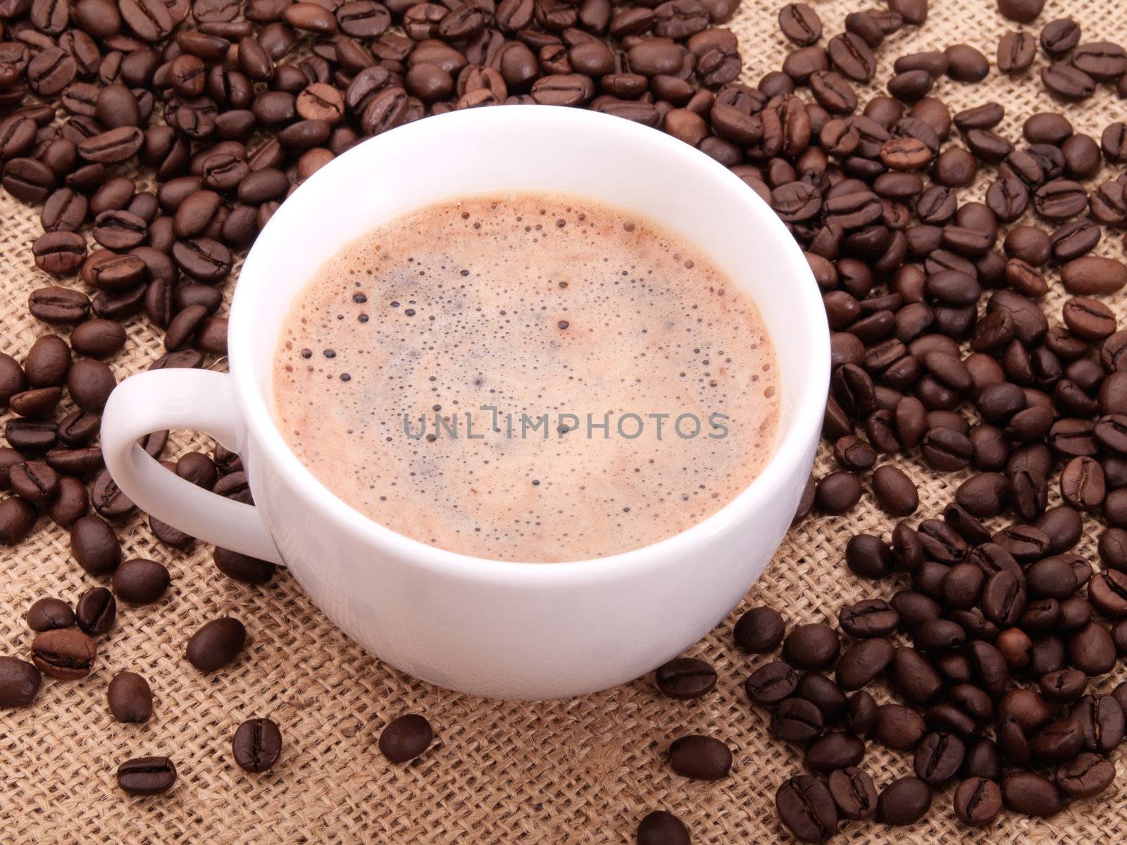 Coffee beans with cup on canvas