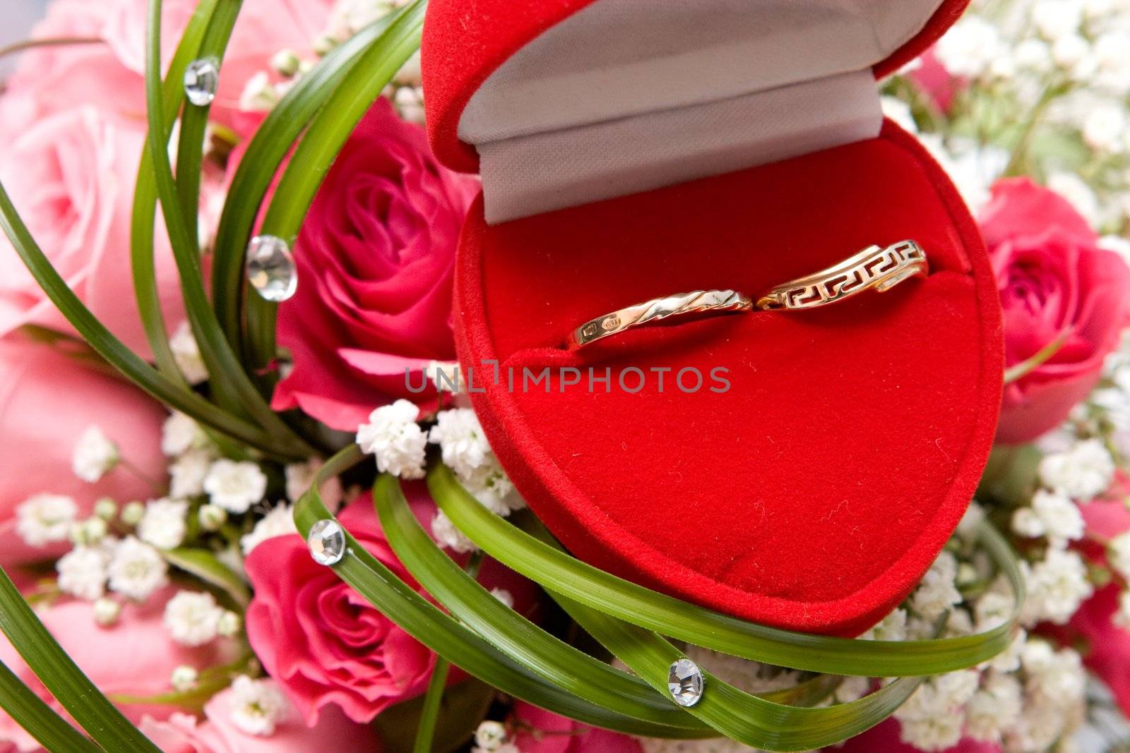 gold rings in box and wedding rose bouquet
