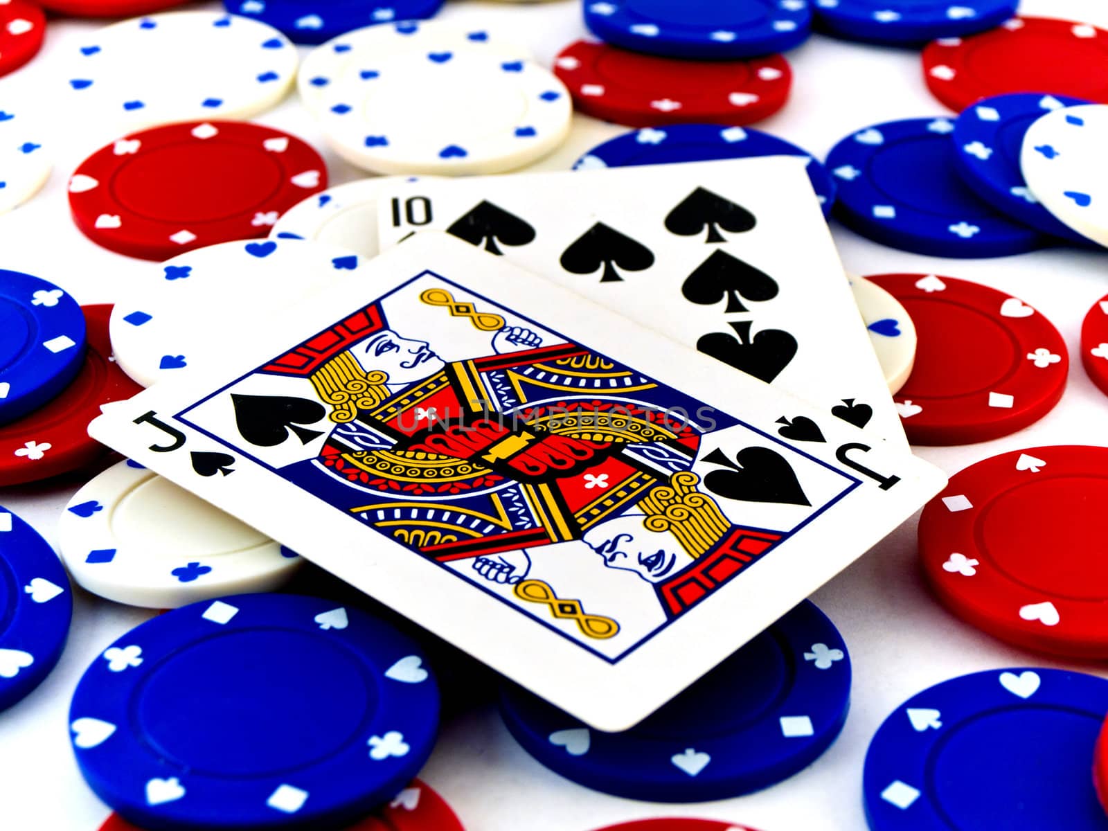 Red White and Blue Poker Chips and Black Jack on White Backgroun by bobbigmac