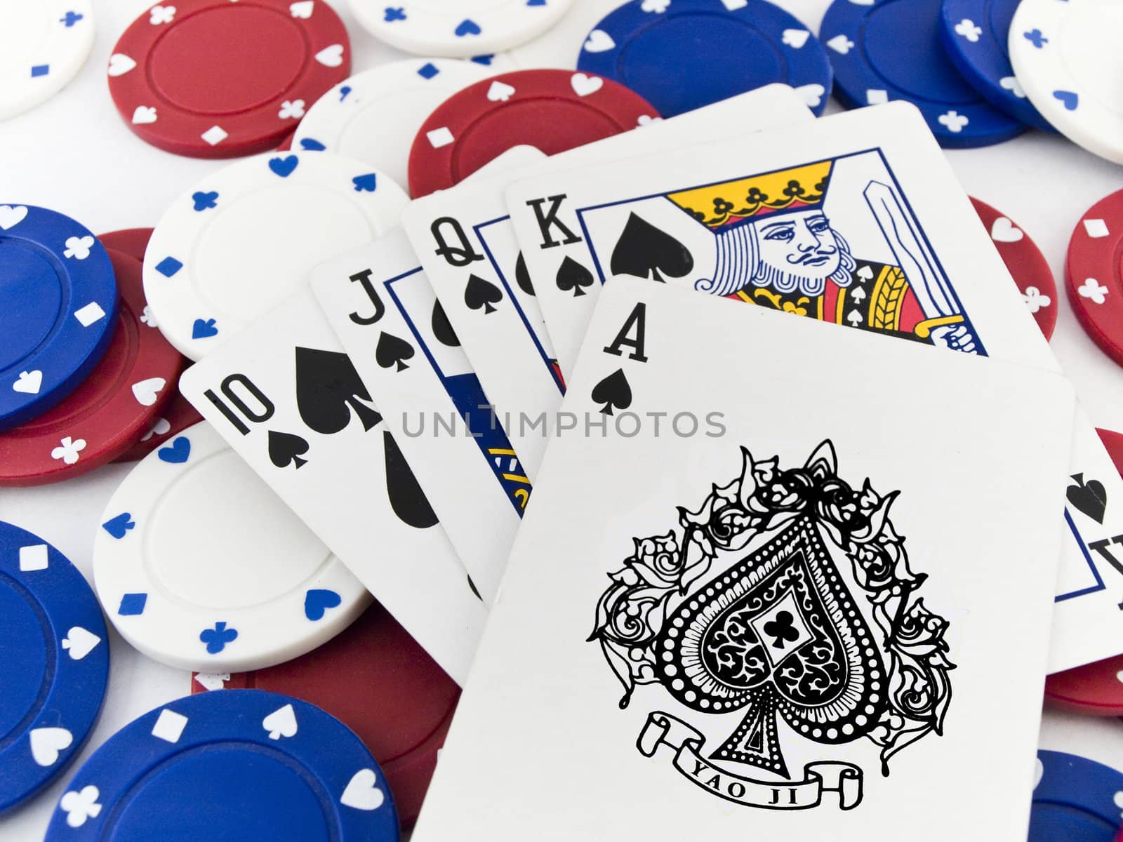 Red White and Blue Poker Chips and Royal Flush on White Backgrou by bobbigmac