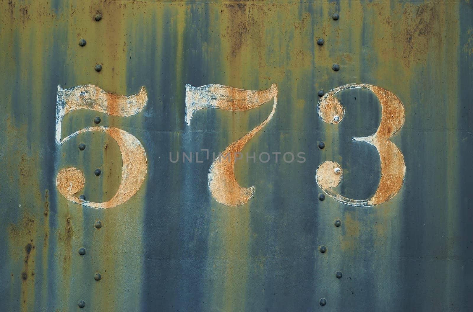 Detail image of the number 573 on the side of a steam powered locomotie engine.