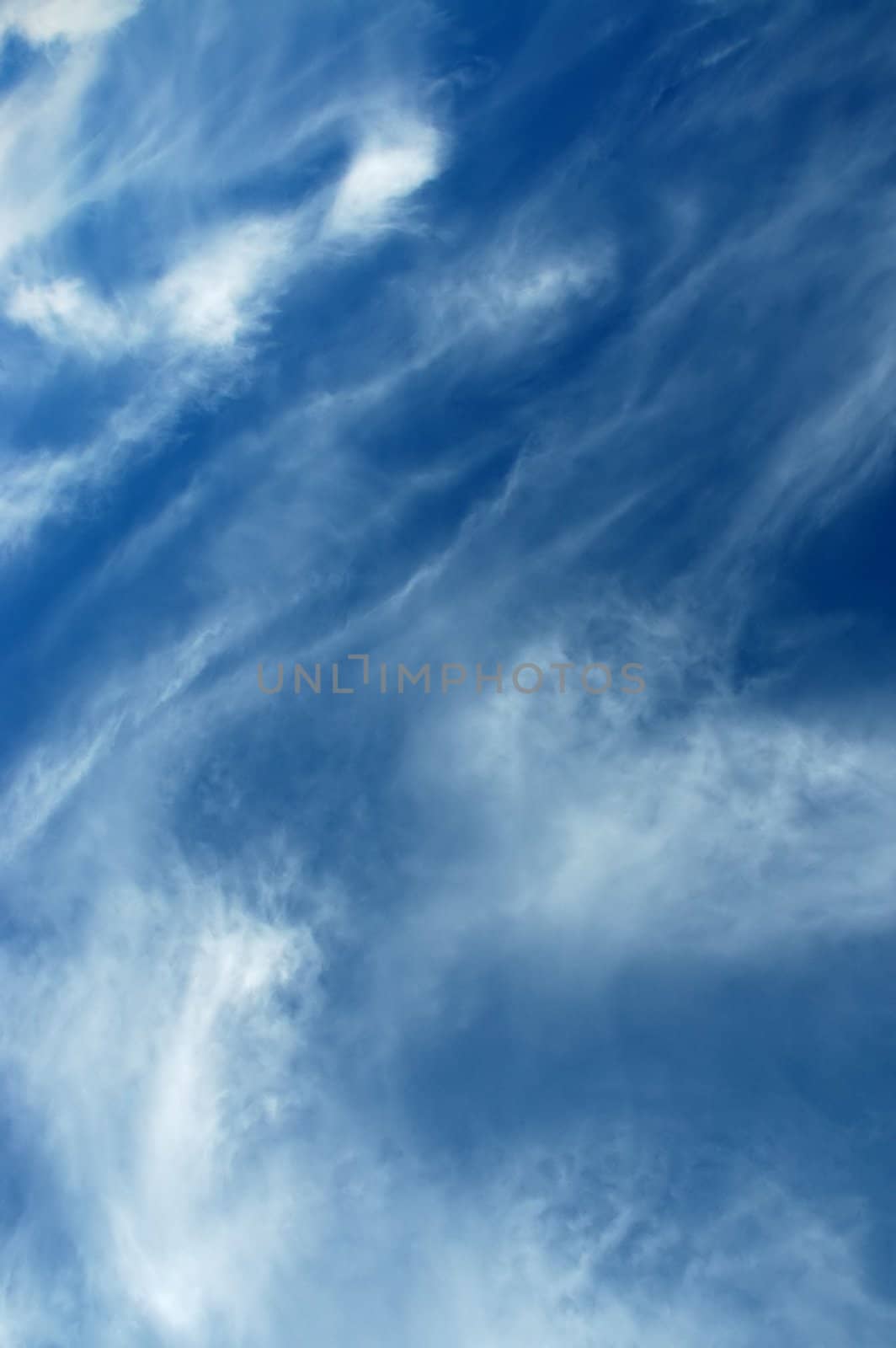 Wispy white clouds on a deep blue sky.