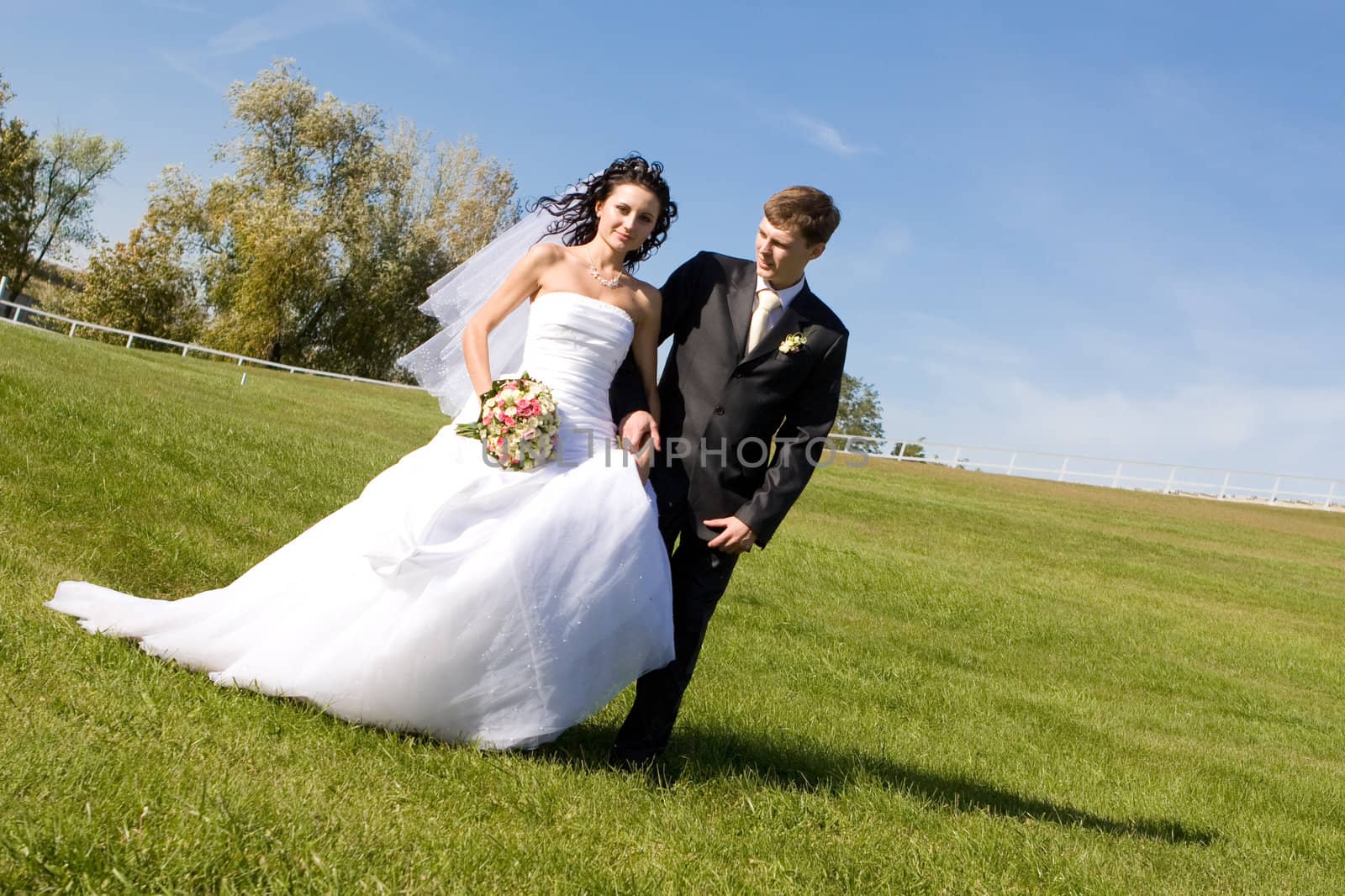 bride and groom walk in the park