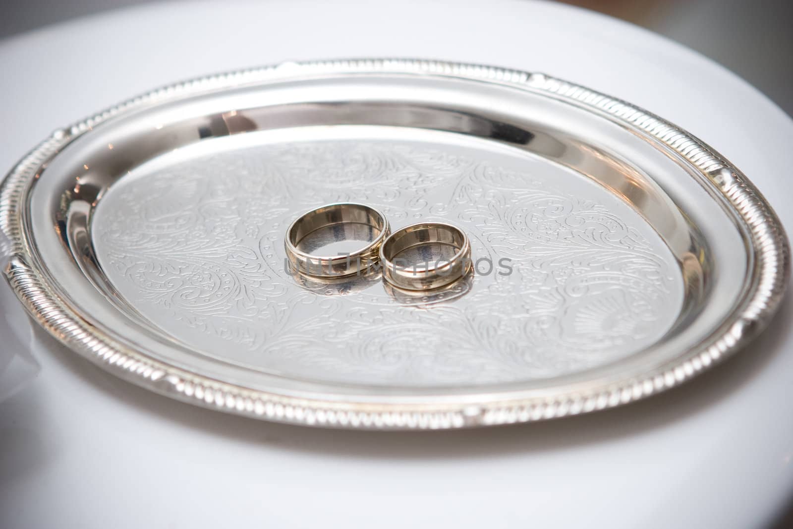 two wedding rings on the decorated plate