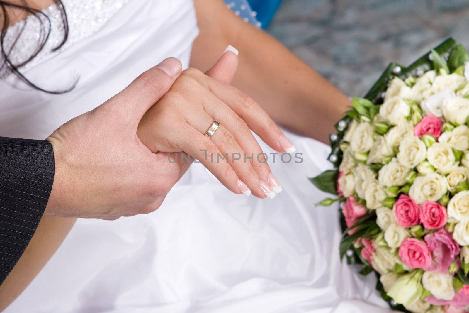hands with gold rings and flower bouquet by vsurkov